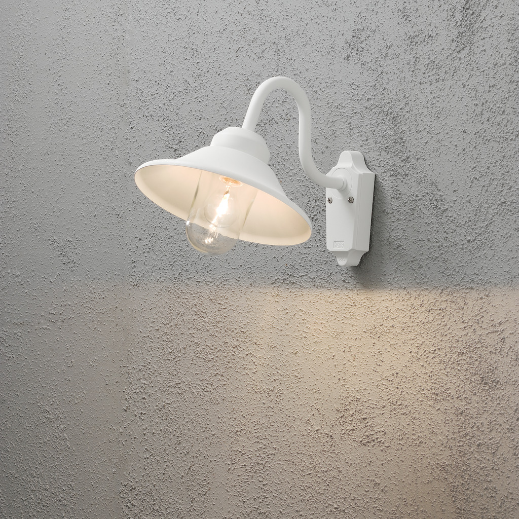 Vega Hvid udendørslampe Fra Konstsmide - Med sin klassiske form og store skygge skaber den et behageligt og rettet lys, perfekt til entre og terrasser.