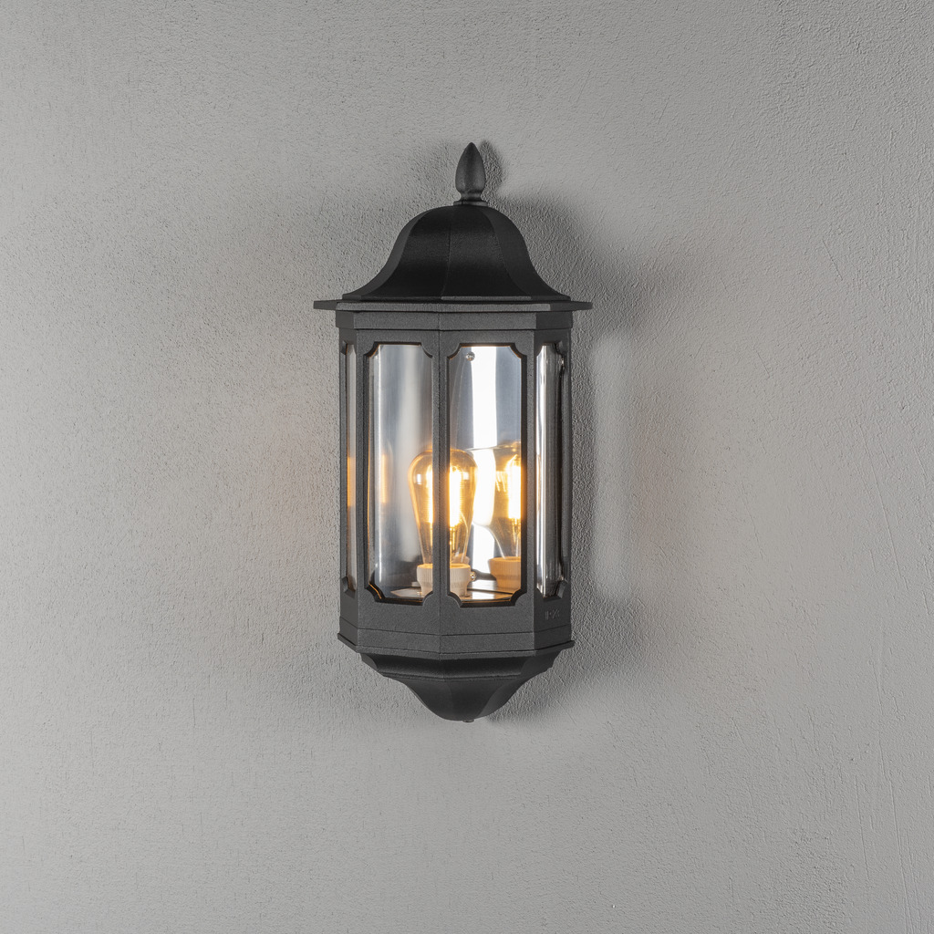 Pallas Sort udendørslampe Fra Konstsmide - Med sit bløde lys skaber den en imødekommende atmosfære, der er perfekt til entre og terrasser.