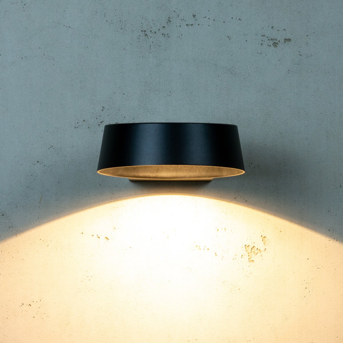 Neptun Sort udendørslampe Fra Dyberg Larsen - Med sin runde form spreder den et stort lysfelt, hvilket g&oslash;r at den passer fint p&aring;; alle typer v&aelig;gge.