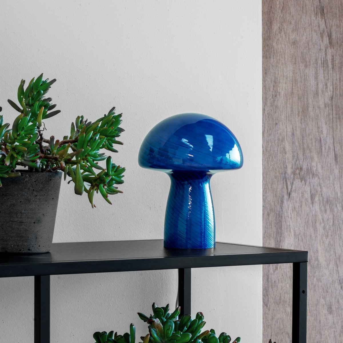 Jenny 23cm Blå bordlampe Fra Dyberg Larsen - Uanset om den er placeret p&aring; et sidebord, vindueskarm, natbord eller skrivebord, er Jenny Mushroom bordlampen et perfekt tilbeh&oslash;r, der fremh&aelig;ver dit hjem med sin charme og elegance.