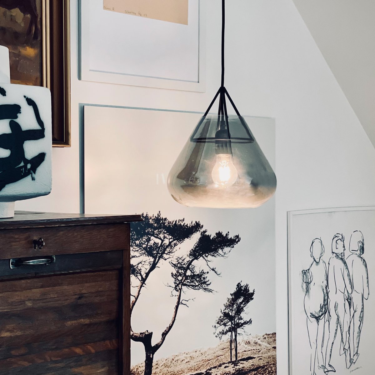 Volta Ø26 Sort loftslampe Fra Dyberg Larsen - Den spreder et fokuseret lys nedenunder, mens åbningen i toppen skaber et dekorativt spil af lys op og ned, der giver rummet både atmosfære og stil.