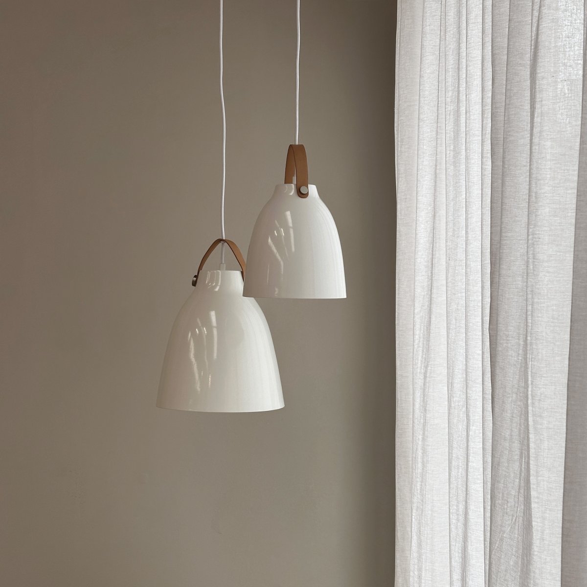 Copenhagen Ø26 Højglans hvid loftslampe Fra Dyberg Larsen - Copenhagen lampen fås i tv&aring; modeller: sort med sort læderrem og hvid med brun læderrem, samt i to forskellige størrelser.