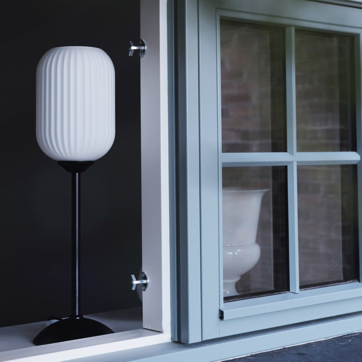 Riflet 52cm Sort bordlampe Fra Dyberg Larsen - Med sin riflede, hvide glaskuppel og stilfulde sorte bund skaber Riflet et blødt og atmosfærisk lys, der forgylder ethvert rum.