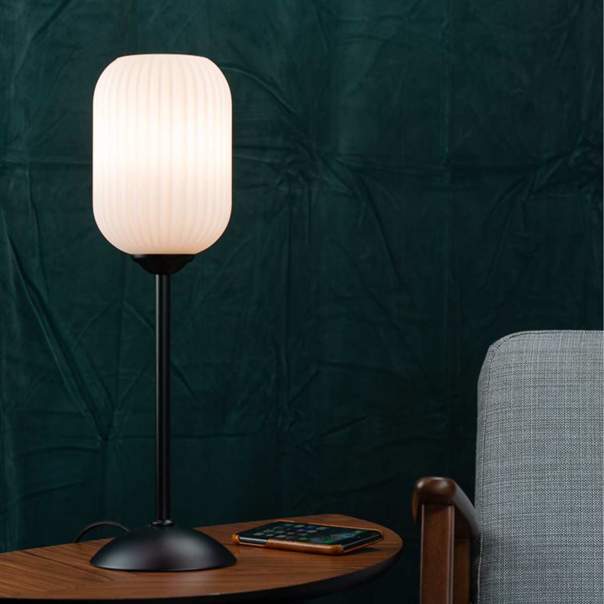 Riflet 52cm Sort bordlampe Fra Dyberg Larsen - Med sin riflede, hvide glaskuppel og stilfulde sorte bund skaber Riflet et blødt og atmosfærisk lys, der forgylder ethvert rum.