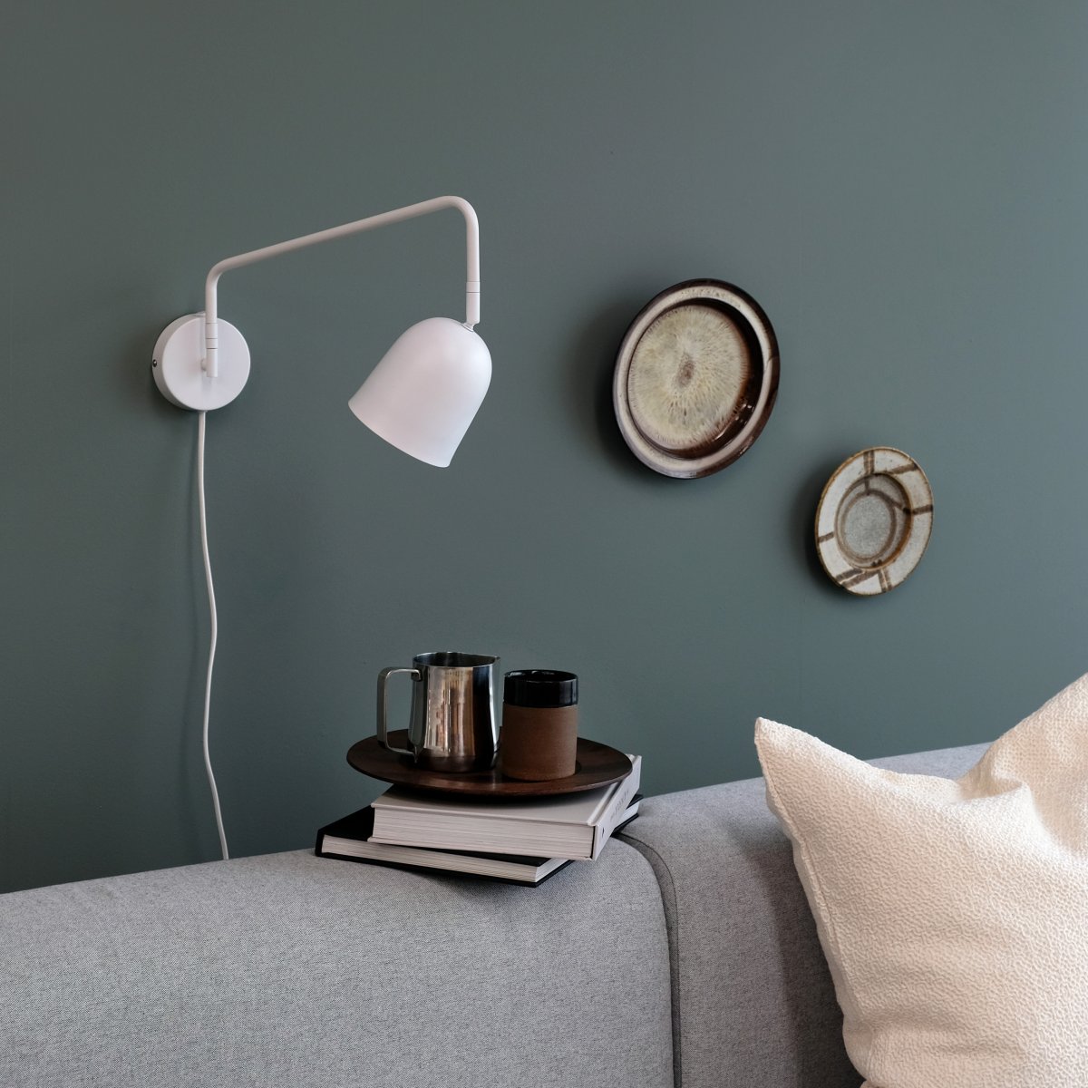 Manchester 45cm Hvid væglampe Fra Dyberg Larsen - Armen p&aring; lampen svinger fra side til side og str&aelig;kker sig 45 cm fra v&aelig;ggen til det yderste punkt af sk&aelig;rmen.