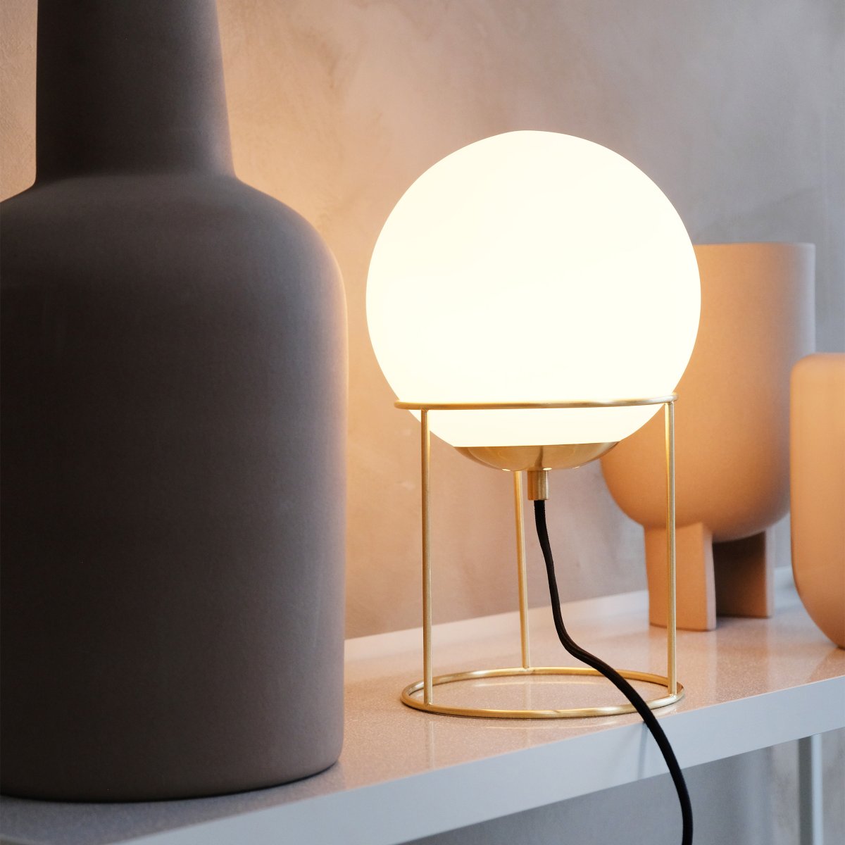 Madrid 34cm Messing bordlampe Fra Dyberg Larsen - Det minimalistiske design passer perfekt ind i både moderne og klassiske interiører og skaber et blødt og behageligt lys, der spreder en varm atmosfære i rummet.