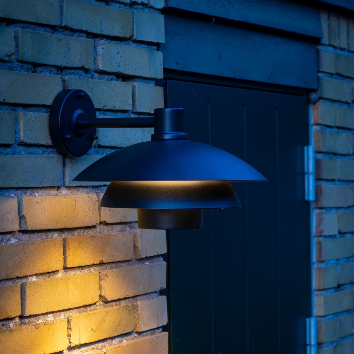 Morph Sort udendørslampe Fra Dyberg Larsen - Skab en indbydende atmosfære ved din hoveddør med Morph udendørsbelysning i en smuk sort metalfarve.