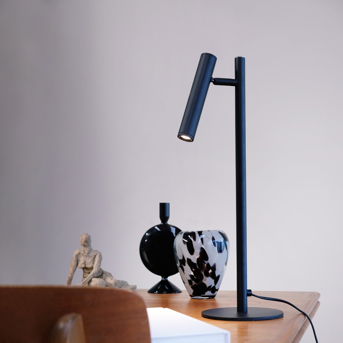 Carlo 48cm Sort skrivebordslampe Fra Dyberg Larsen - Den har en indbygget LED og en trinløs lysdæmper, der styres med en touch-knap.