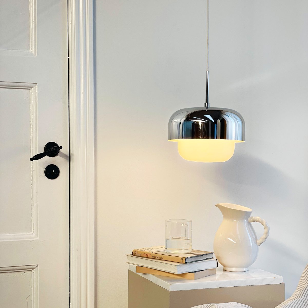 Haipot Ø23 Krom loftslampe Fra Dyberg Larsen - Det stilfulde design kombinerer en &oslash;vre metalsk&aelig;rm med en forkromet finish og en nedre del i hvidt glas, der spreder et j&aelig;vnt og behageligt lys.