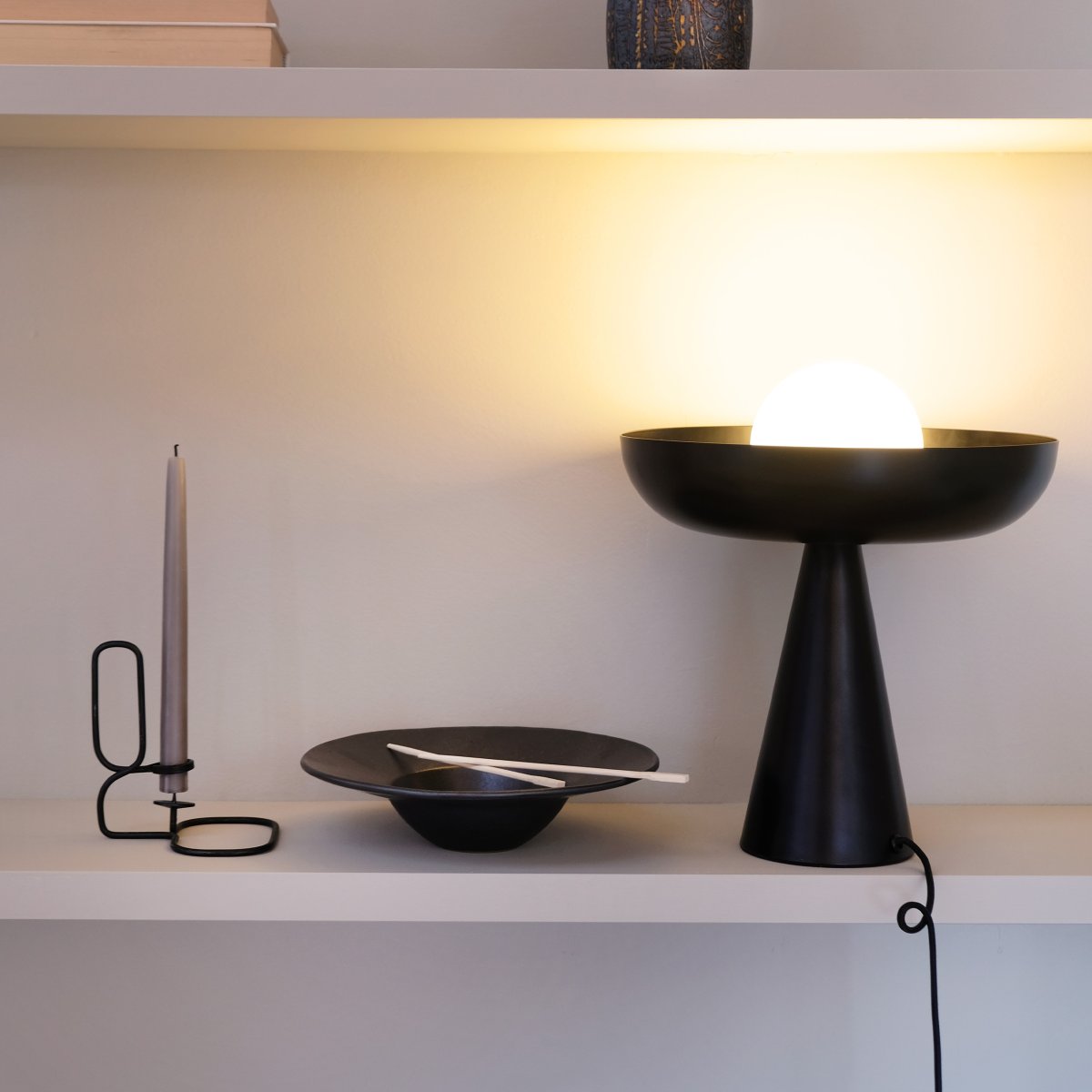Ava 35cm Sort bordlampe Fra Dyberg Larsen - Kombinationen af den sorte metalbund og den elegante glaskuppel omgiver lyset p&aring; en fortryllende måde, som skaber et unikt og iøjnefaldende lyspunkt i dit interiør.