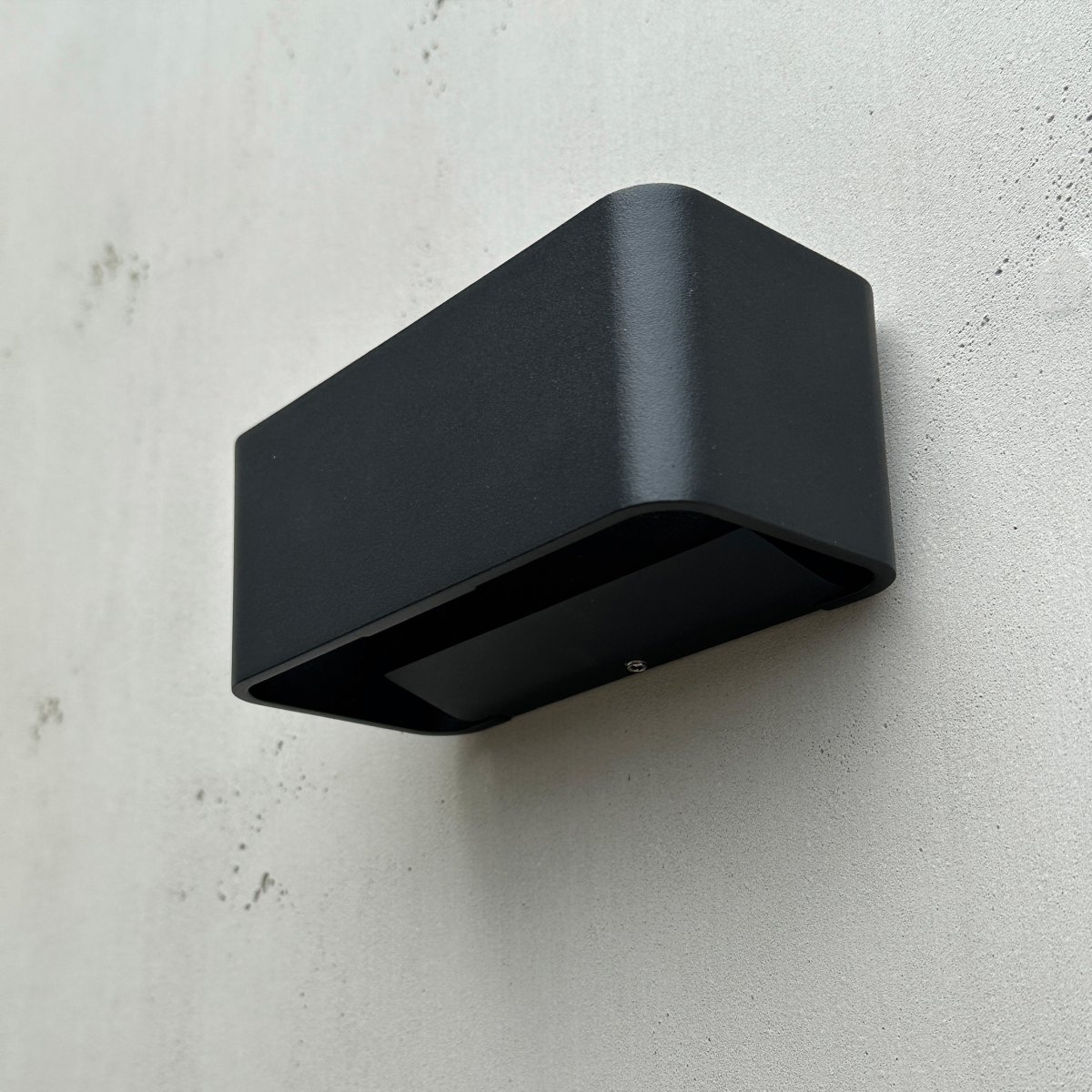 Saturn Sort udendørslampe Fra Dyberg Larsen - Med sit minimalistiske design og robuste konstruktion er den perfekt til udendørs brug og giver din facade et elegant løft.