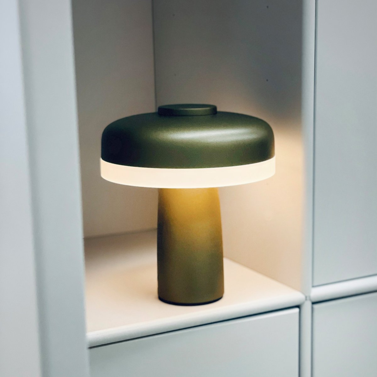 Porter 16cm Metallisk grøn bærbar Fra Dyberg Larsen - Porter LED genopladelig bordlampe er en moderne og funktionel lampe med et unikt design, hvor lyset kommer fra kanten, hvilket giver et behageligt og jævnt lys.