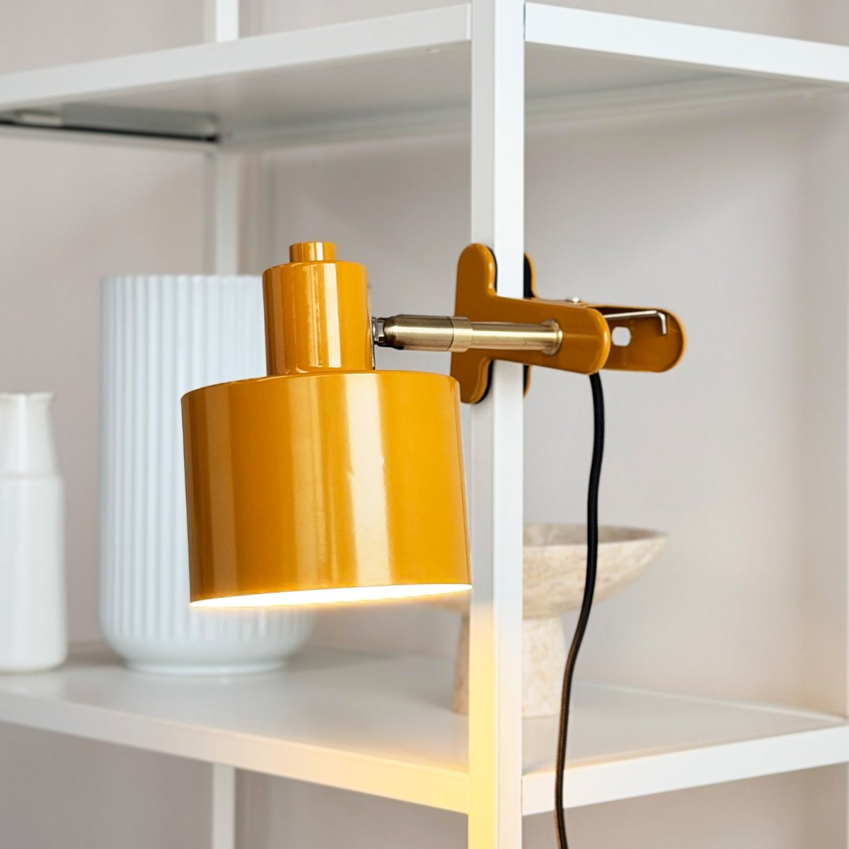 Ocean Gul klemmelampe Fra Dyberg Larsen - Den kombinerer funktionalitet med et moderne og enkelt design, der skaber et roligt og elegant udtryk.