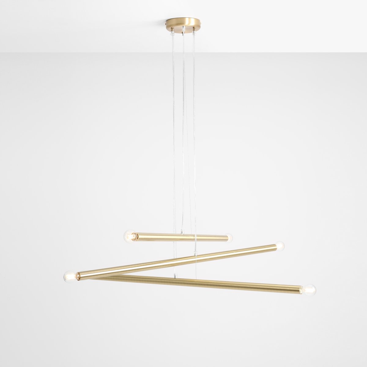 Tubo 6 100cm Messing loftslampe Fra Artera - Lampen består af tre smalle metalrør i en elegant messingfinish, placeret i forskellige højder og vinkler, der skaber et spændende og luftigt udtryk.