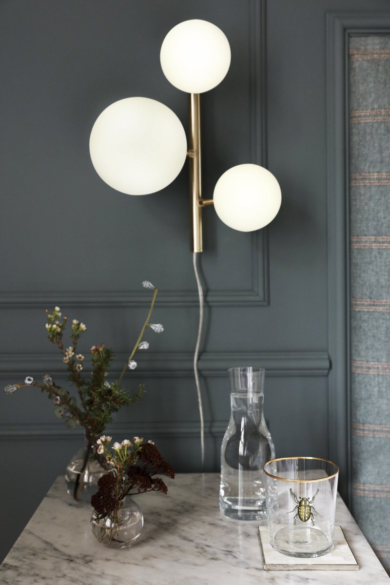 Molekyl 36cm Mat messing væglampe Fra Aneta Lighting - Den er lavet af metal med en elegant mat messingfinish og har opalhvide glasskærme, der spreder et blødt og behageligt lys.