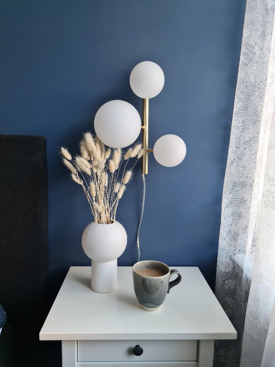 Molekyl 36cm Mat messing væglampe Fra Aneta Lighting - Den er lavet af metal med en elegant mat messingfinish og har opalhvide glasskærme, der spreder et blødt og behageligt lys.