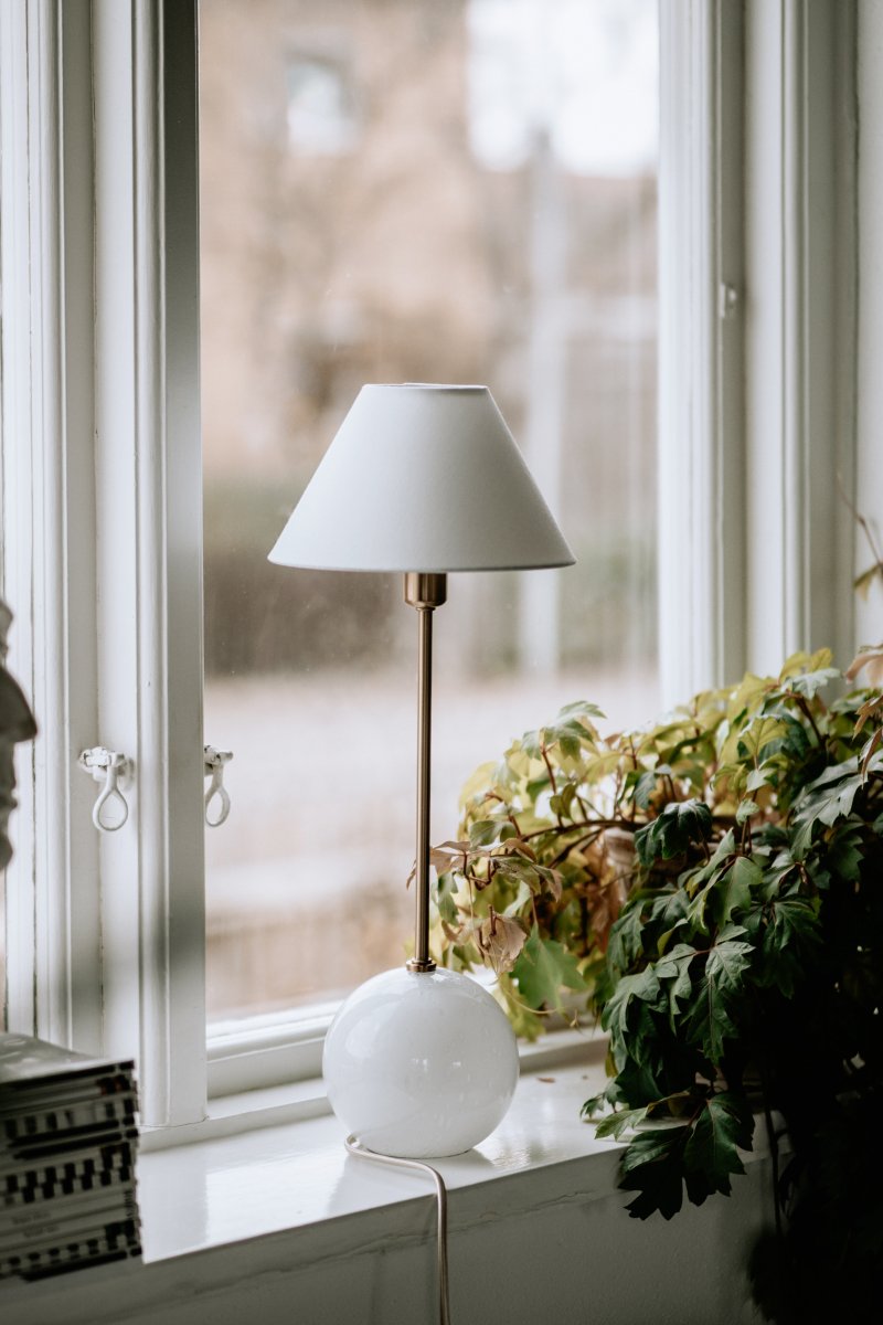 Iris 50cm Hvid bordlampe Fra Globen Lighting - Iris er en smuk bordlampe lavet af farvet glas med bl&aelig;ste luftbobler med en matchende bomuldssk&aelig;rm og en t&oslash;r top, der g&aring;r tone-i-tone med lampefoden.