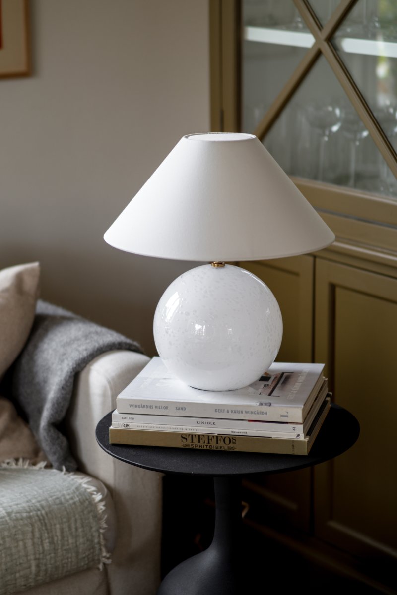 Iris 40cm Hvid bordlampe Fra Globen Lighting - Iris er en smuk bordlampe lavet af farvet glas med bl&aelig;ste luftbobler med en matchende bomuldssk&aelig;rm og en t&oslash;r top, der g&aring;r tone-i-tone med lampefoden.
