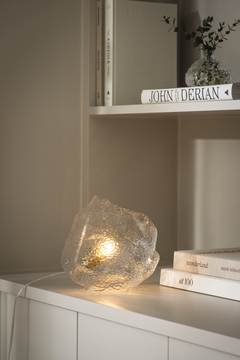 Valerie 22cm Gennemsigtig bordlampe Fra Globen Lighting - Det mundblæste glas med sin strukturerede overflade fanger lyset og skaber et levende lysspil.