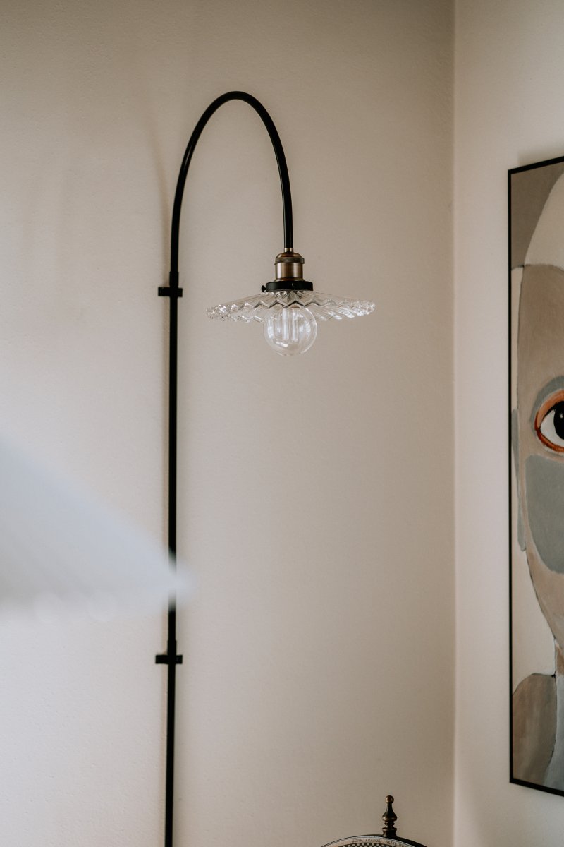 Cobbler 60cm Gennemsigtig/sort væglampe Fra Globen Lighting - Vægbeslaget har to metalbeslag og medfølgende skruer til montering på væggen, og hele lampen er justerbar i sideretningen.