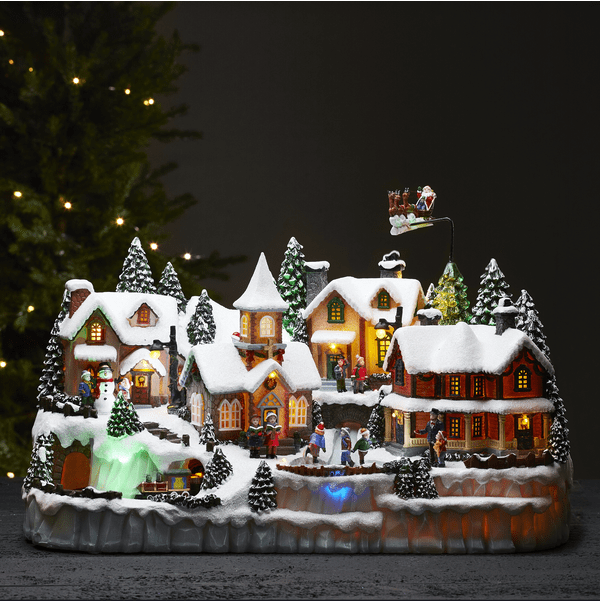Largeville Flerfarvet Fra Star Trading - Stor og detaljeret juledekoration i form af en landsby med tre forskellige roterende dele; togs&aelig;t, b&oslash;rn, der sk&oslash;jter, og rensdyr med kane og julemand.