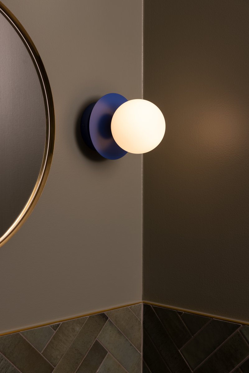 Art Deco Ø16 Blå/hvid badeværelseslampe Fra Globen Lighting - Lampen er lavet af metal og har en hvid glasskærm, der skaber en flot lysspredning i rummet.