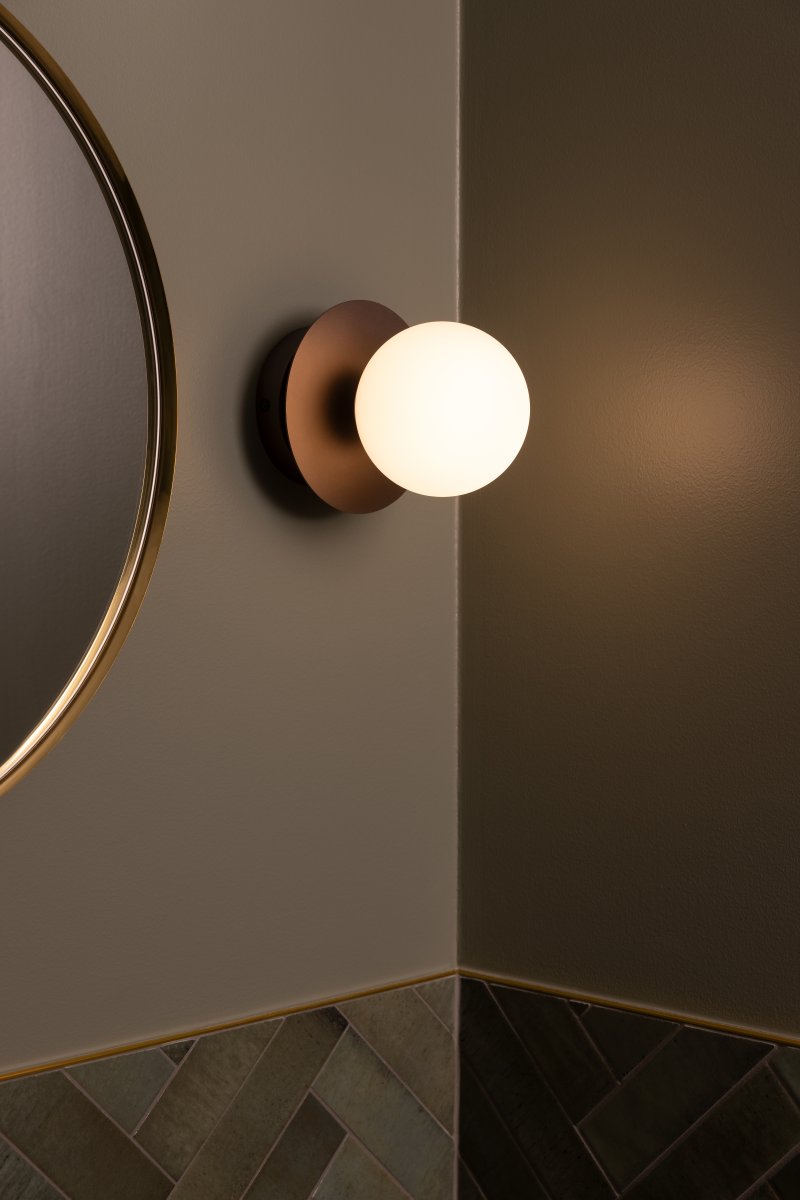 Art Deco Ø16 Bronze/hvid badeværelseslampe Fra Globen Lighting - Lampen er lavet af metal og har en hvid glasskærm, der skaber en flot lysspredning i rummet.
