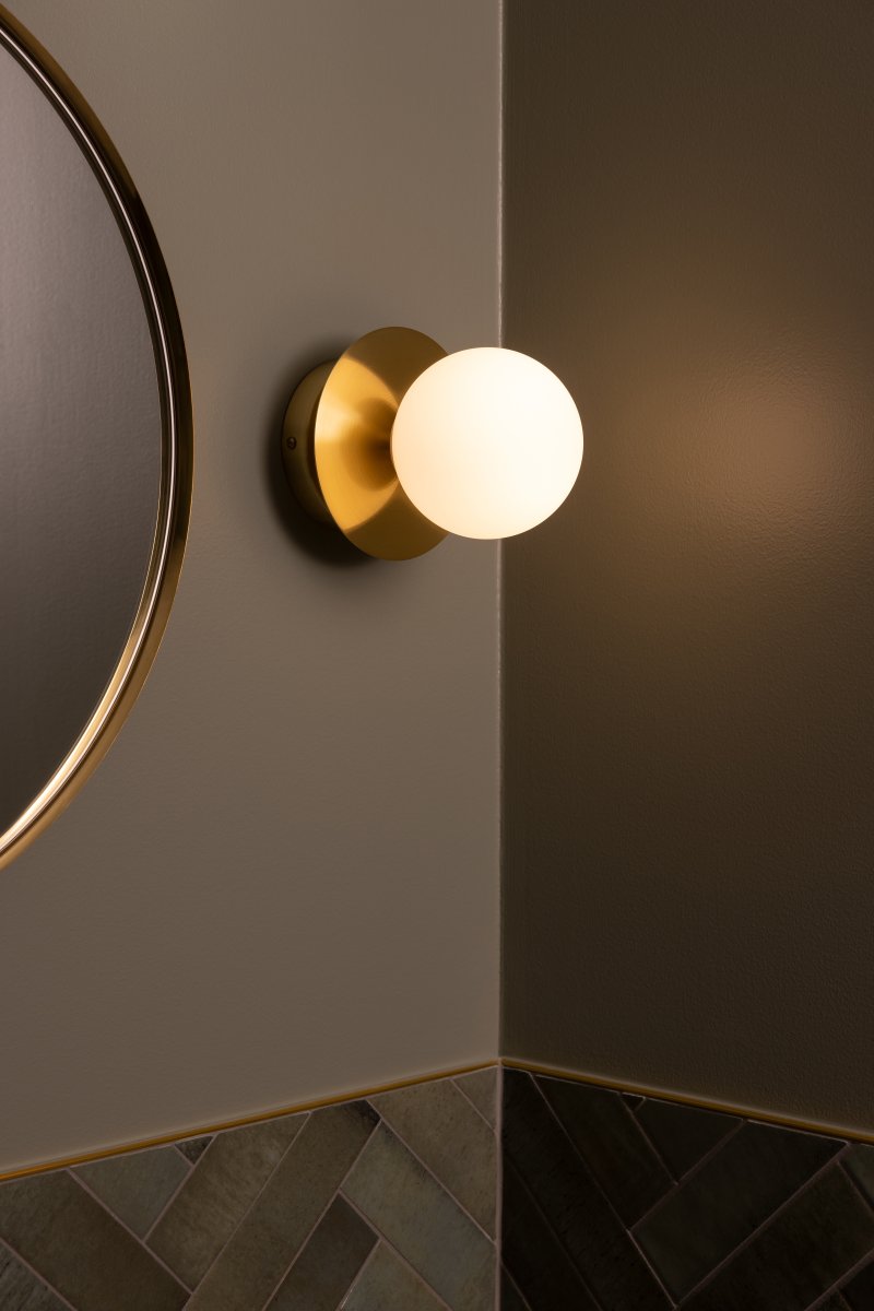 Art Deco Ø16 Børstet messing/hvid badeværelseslampe Fra Globen Lighting - Lampen er lavet af metal og har en hvid glassk&aelig;rm, der skaber en flot lysspredning i rummet.