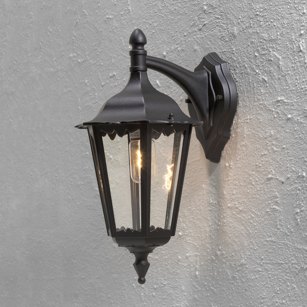 Firenze Sort udendørslampe Fra Konstsmide - Lampens elegante design og varme lys skaber en indbydende atmosf&aelig;re, der er perfekt til entre og terrasser.