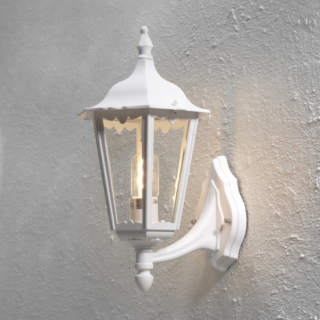 Firenze Hvid udendørslampe Fra Konstsmide - Lampens elegante design og varme lys skaber en indbydende atmosfære, der er perfekt til entre og terrasser.