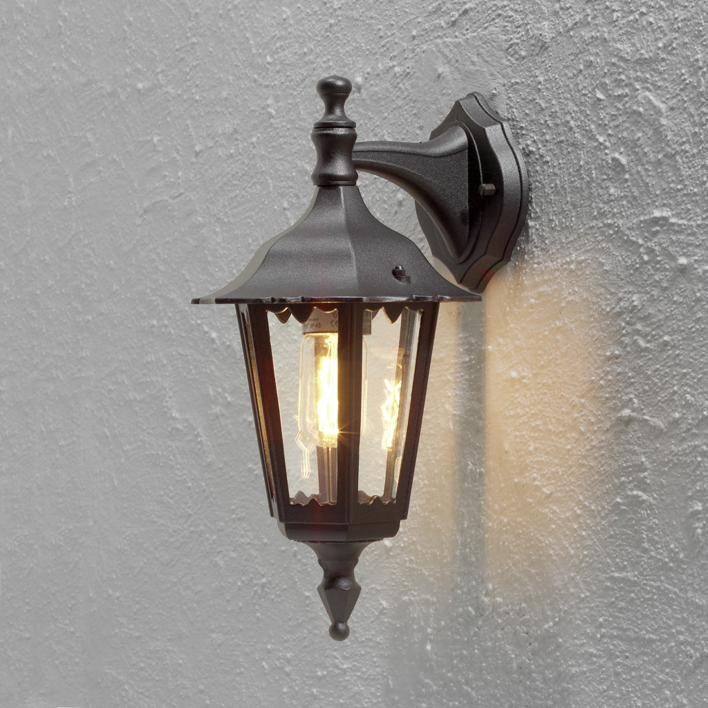Firenze Sort udendørslampe Fra Konstsmide - Lampens elegante design og varme lys skaber en indbydende atmosfære, der er perfekt til entre og terrasser.