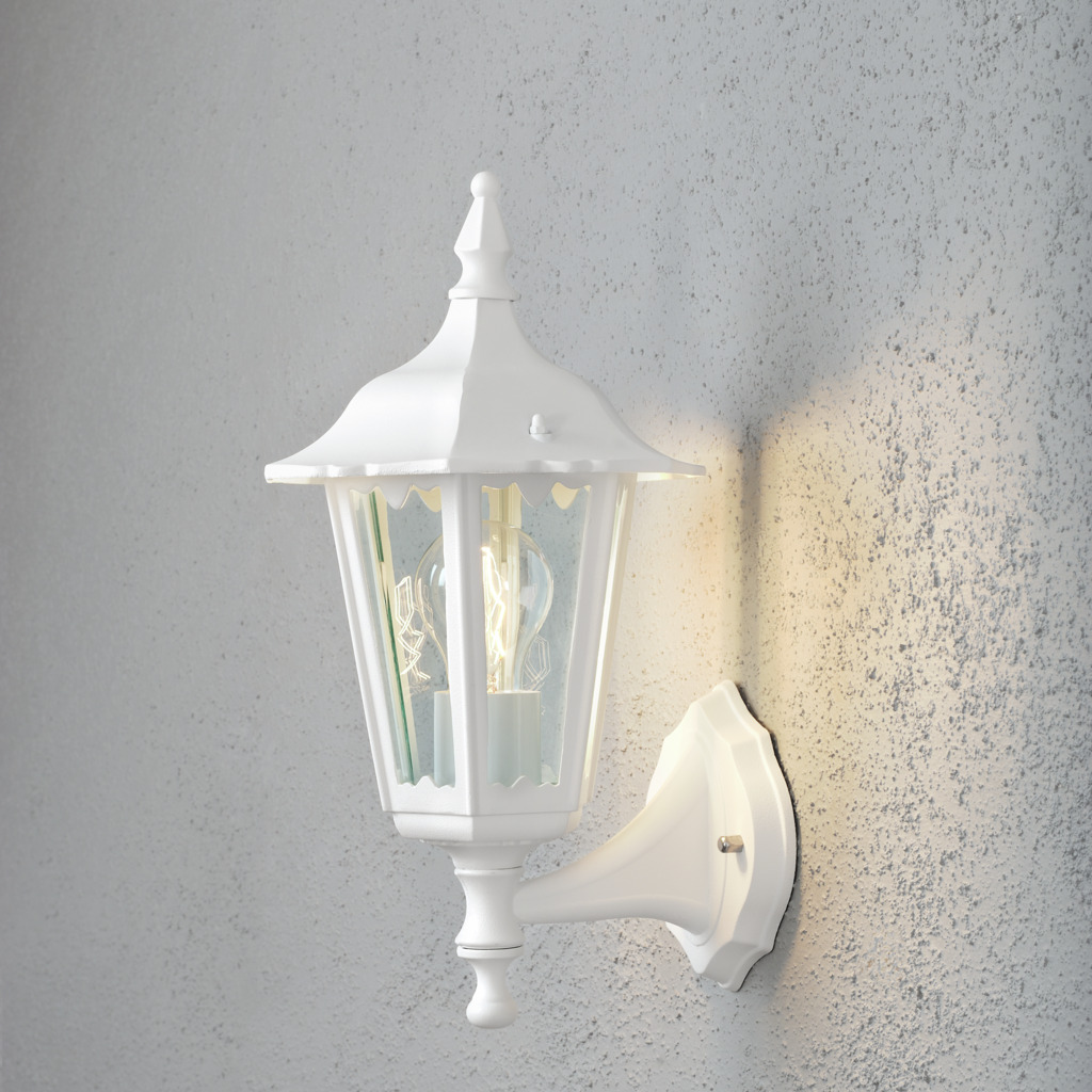 Firenze Hvid udendørslampe Fra Konstsmide - Lampens elegante design og varme lys skaber en indbydende atmosf&aelig;re, der er perfekt til entre og terrasser.