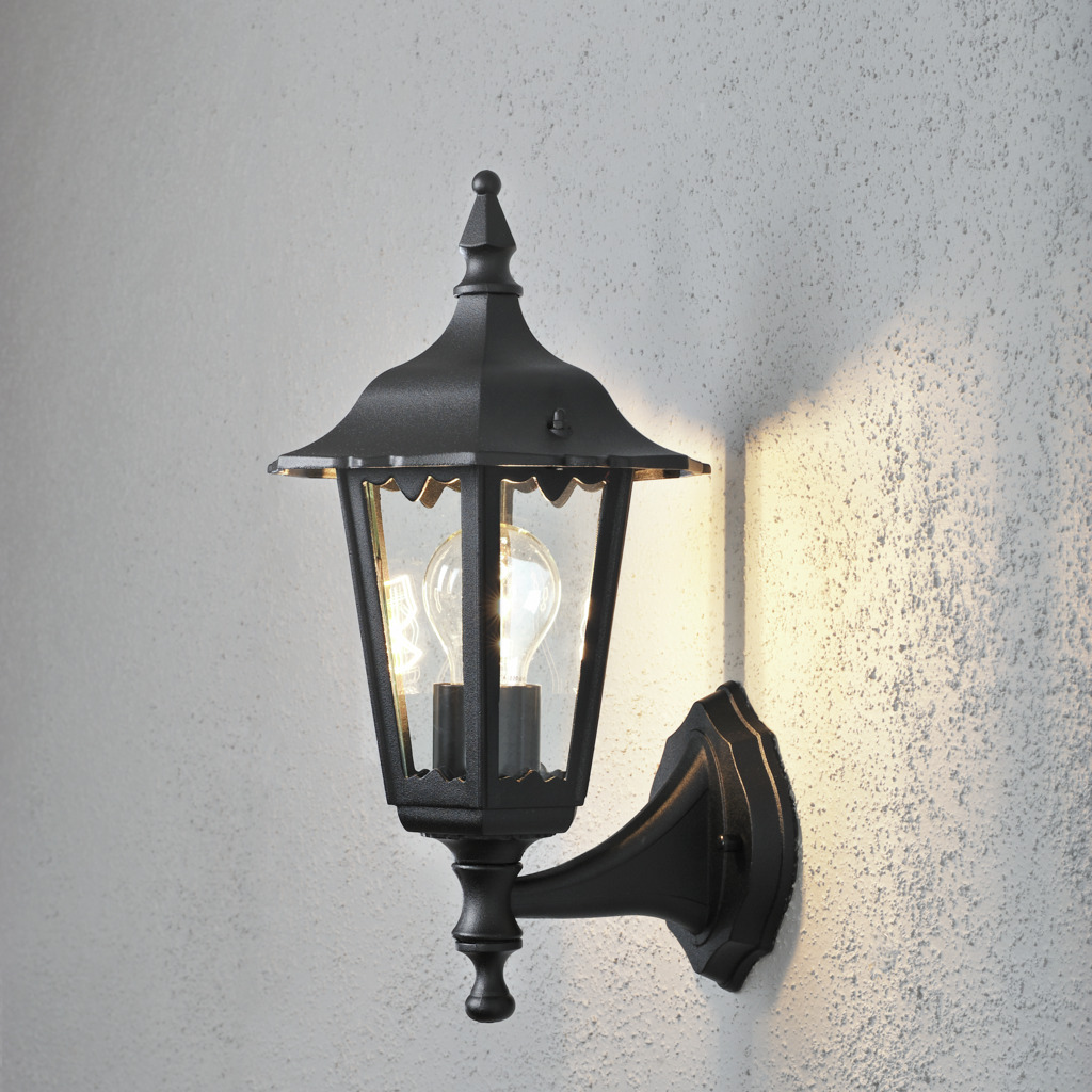 Firenze Sort udendørslampe Fra Konstsmide - Lampens elegante design og varme lys skaber en indbydende atmosfære, der er perfekt til entre og terrasser.