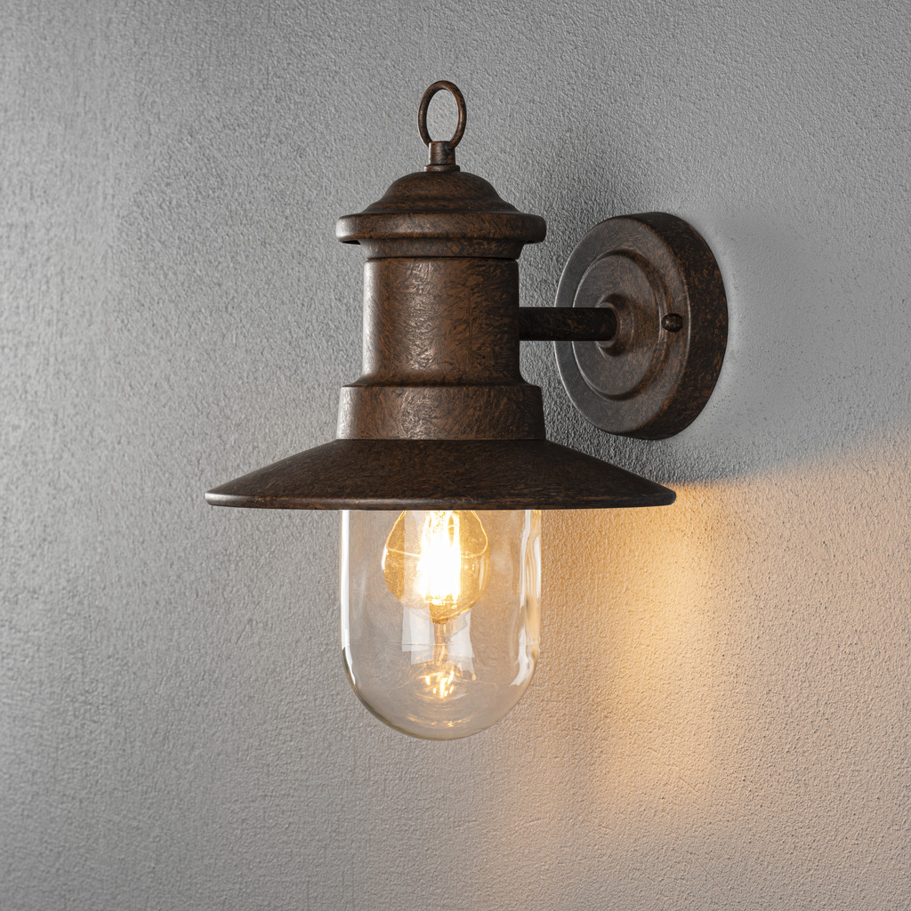 Napoli Rust udendørslampe Fra Konstsmide - Lampens klassiske design med en rund glaskuppel og en bred skærm spreder et varmt og behageligt lys, perfekt til at oplyse indgange og terrasser.