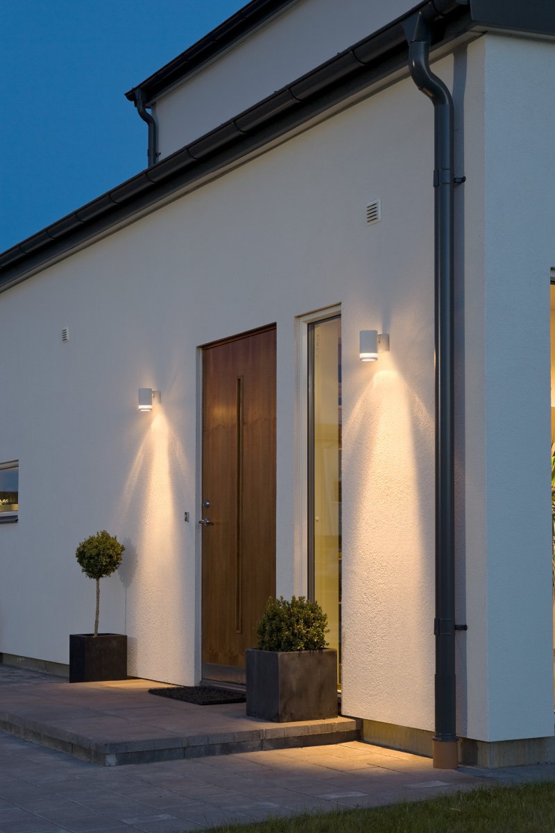 Modena Hvid udendørslampe Fra Konstsmide - Modena er en stilfuld facadelampe i hvidlakeret aluminium med en elegant detalje i transparent akrylglas, der giver lampen et moderne udtryk.