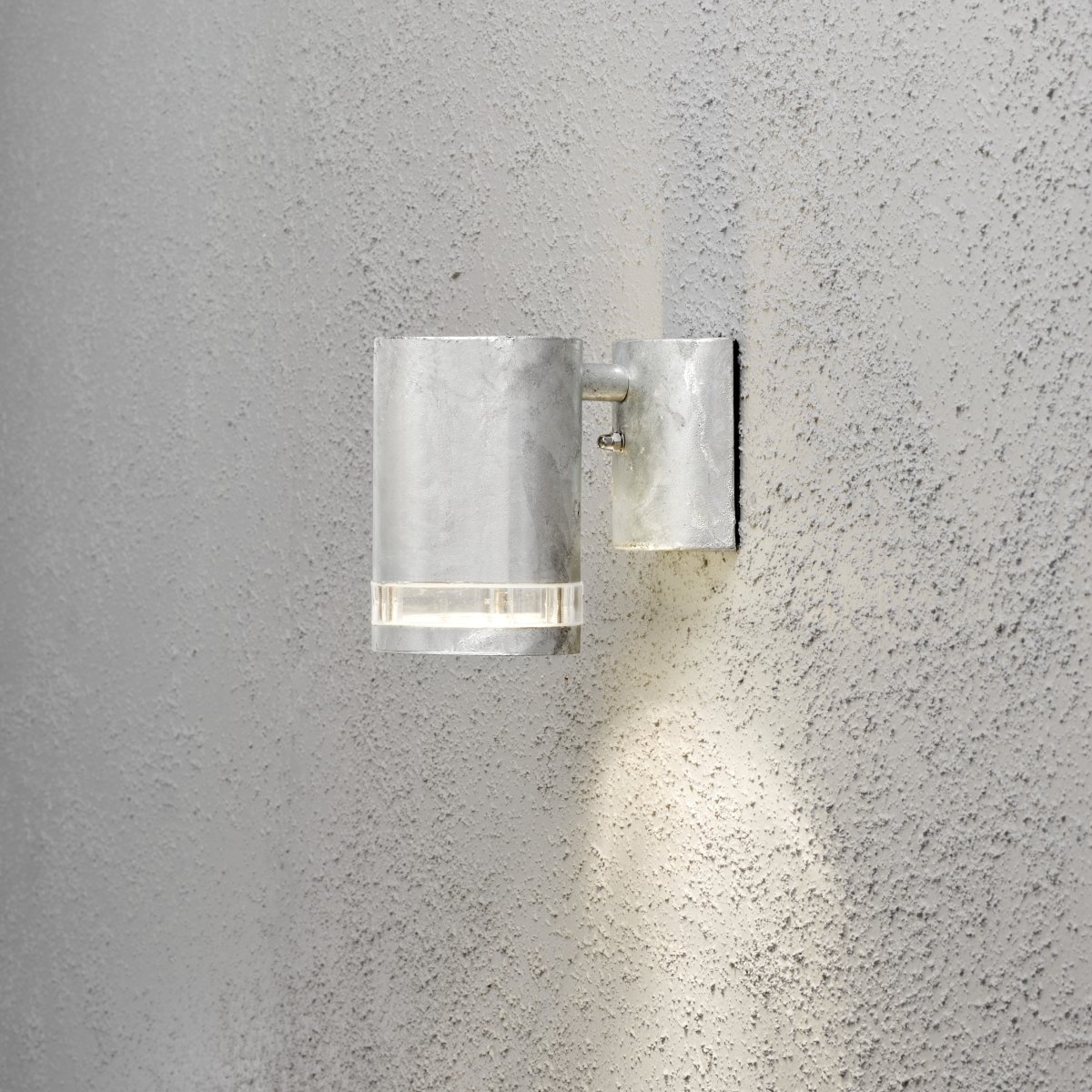 Modena Galvaniseret udendørslampe Fra Konstsmide - Modena er en stilfuld facadelampe fremstillet af galvaniseret metalplade med en elegant detalje i transparent akrylglas, der giver lampen et moderne udtryk.