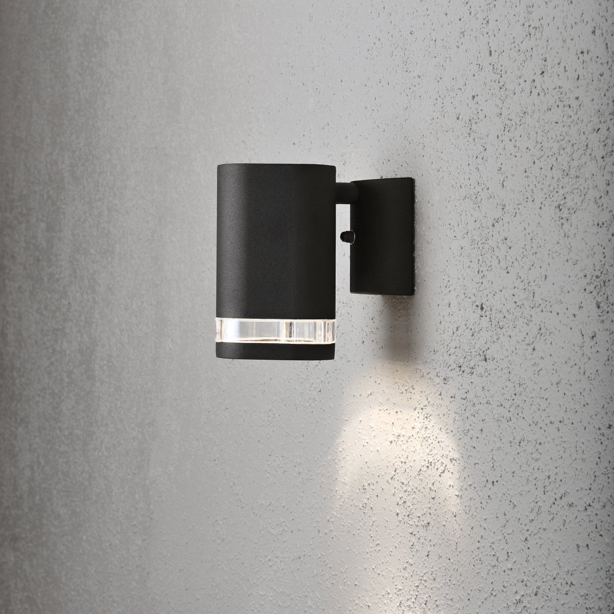 Modena Sort udendørslampe Fra Konstsmide - Modena er en stilfuld facadelampe i sortlakeret aluminium med en elegant detalje i transparent akrylglas, der giver lampen et moderne udtryk.