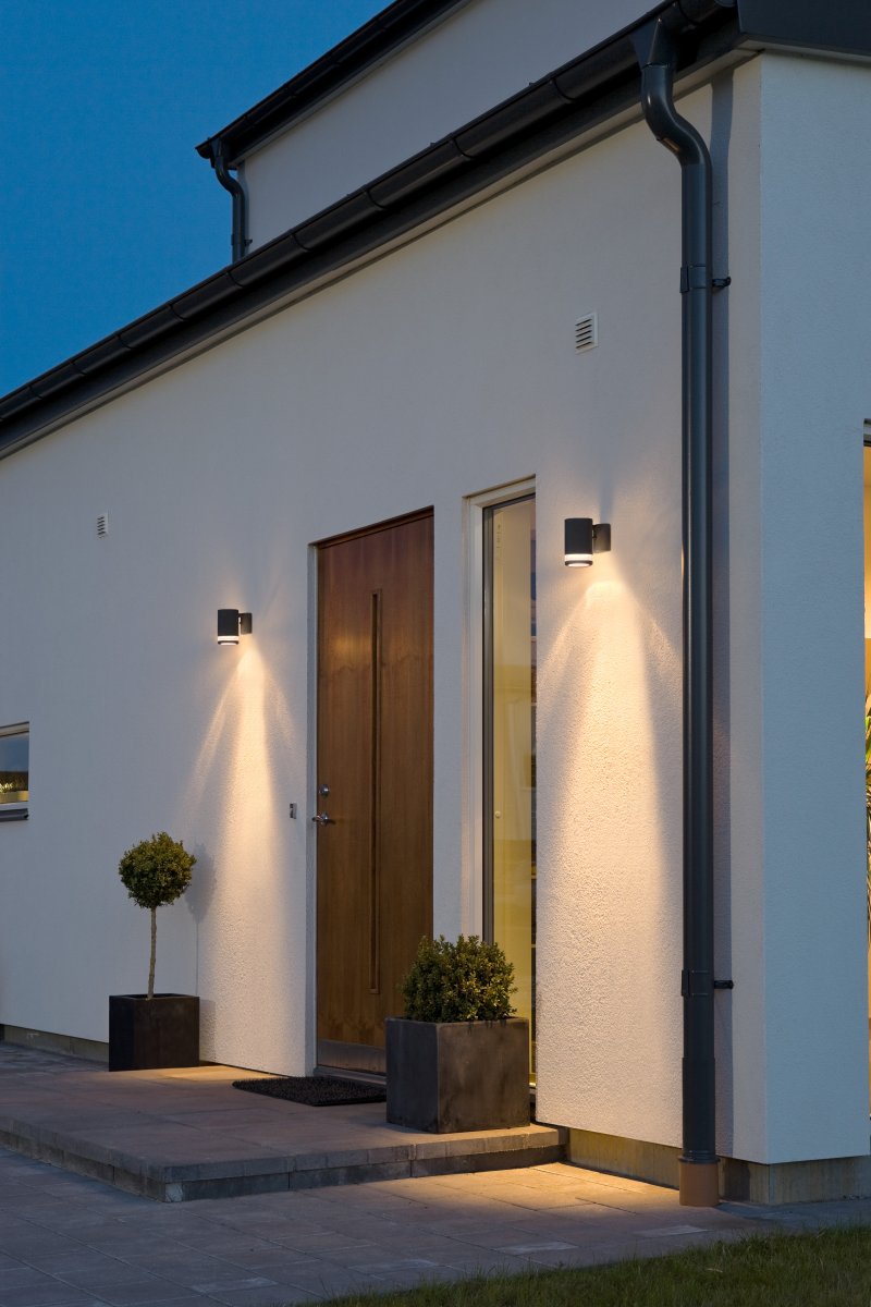 Modena Sort udendørslampe Fra Konstsmide - Modena er en stilfuld facadelampe i sortlakeret aluminium med en elegant detalje i transparent akrylglas, der giver lampen et moderne udtryk.