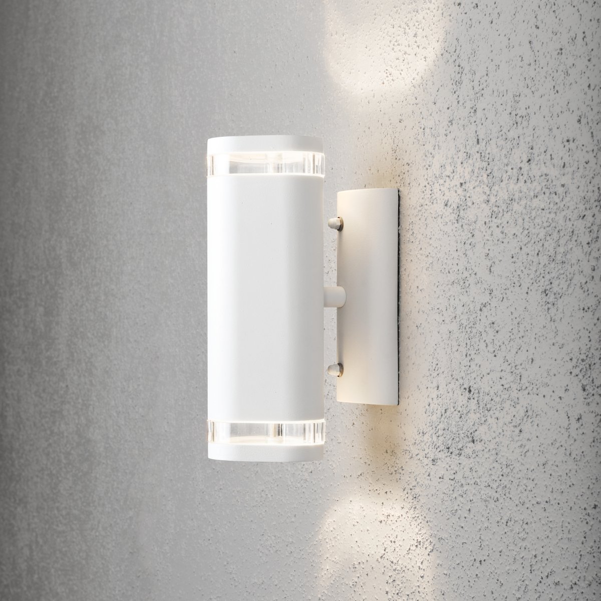 Modena II Hvid udendørslampe Fra Konstsmide - Lyset er rettet b&aring;de opad og nedad og skaber et dekorativt og effektfuldt lysbillede, der l&oslash;fter facaden og giver haven en indbydende fornemmelse.