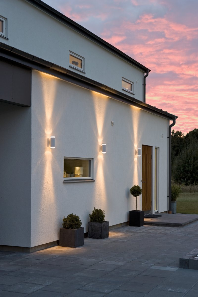Modena II Hvid udendørslampe Fra Konstsmide - Lyset er rettet b&aring;de opad og nedad og skaber et dekorativt og effektfuldt lysbillede, der l&oslash;fter facaden og giver haven en indbydende fornemmelse.