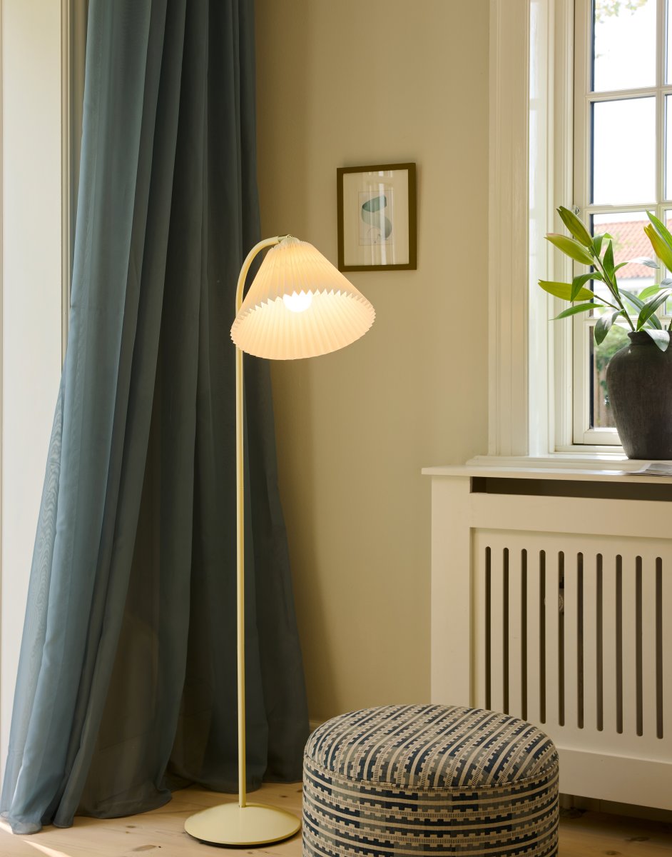 Medina Cremet hvid gulvlampe Fra Halo Design - Den cremehvide metalramme suppleres af en smuk plisseret tekstilskærm i matchende skærm og dekorative detaljer i messing.