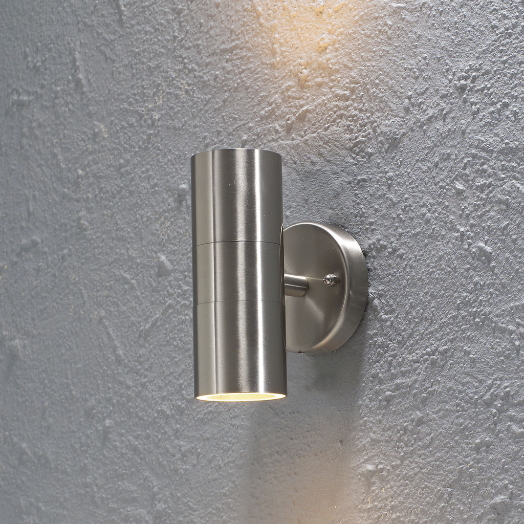 Modena Sølv udendørslampe Fra Konstsmide - Skab en elegant og moderne belysningsløsning til din facade med denne væglampe i rustfrit stål, der lyser både op og ned.