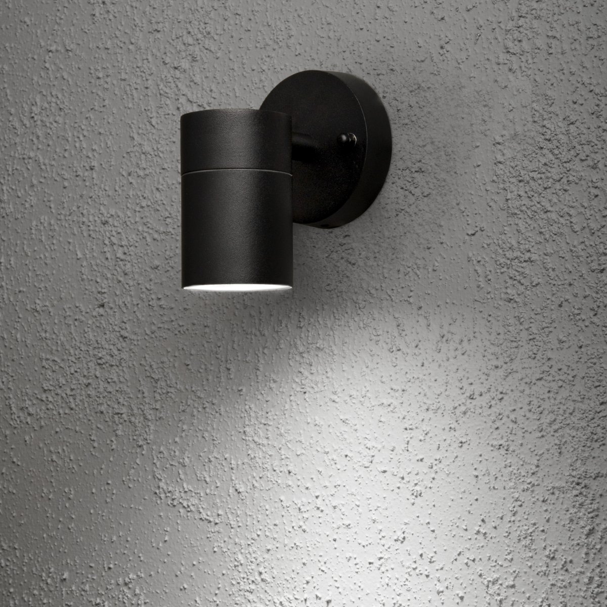 Modena Sort udendørslampe Fra Konstsmide - Lyset er rettet nedad og skaber et bl&oslash;dt og effektivt lysbillede, der fremh&aelig;ver facaden og giver en behagelig udend&oslash;rsbelysning.