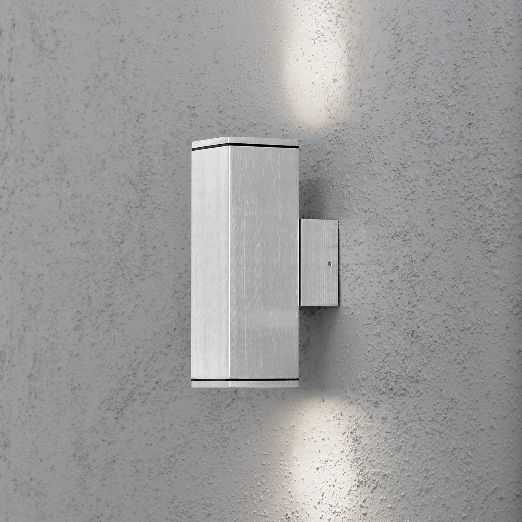 Monza Sølv udendørslampe Fra Konstsmide - Skab en elegant og moderne belysningsløsning til din facade med denne væglampe i anodiseret finish, der skinner både op og ned.