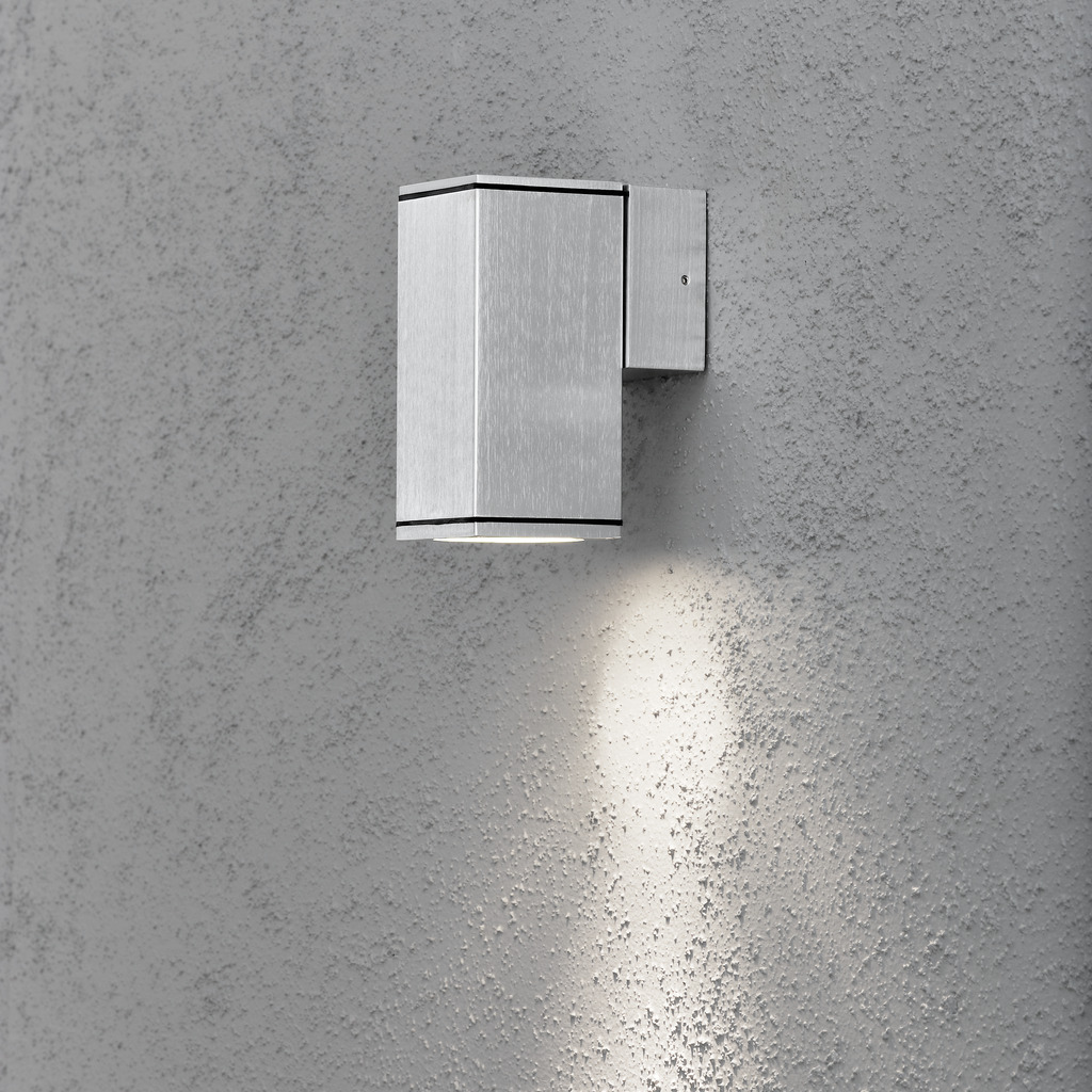 Monza Sølv udendørslampe Fra Konstsmide - Med sit terningformede design og direkte lys er den ideel til at skabe en sofistikeret atmosfære i entre og gange.