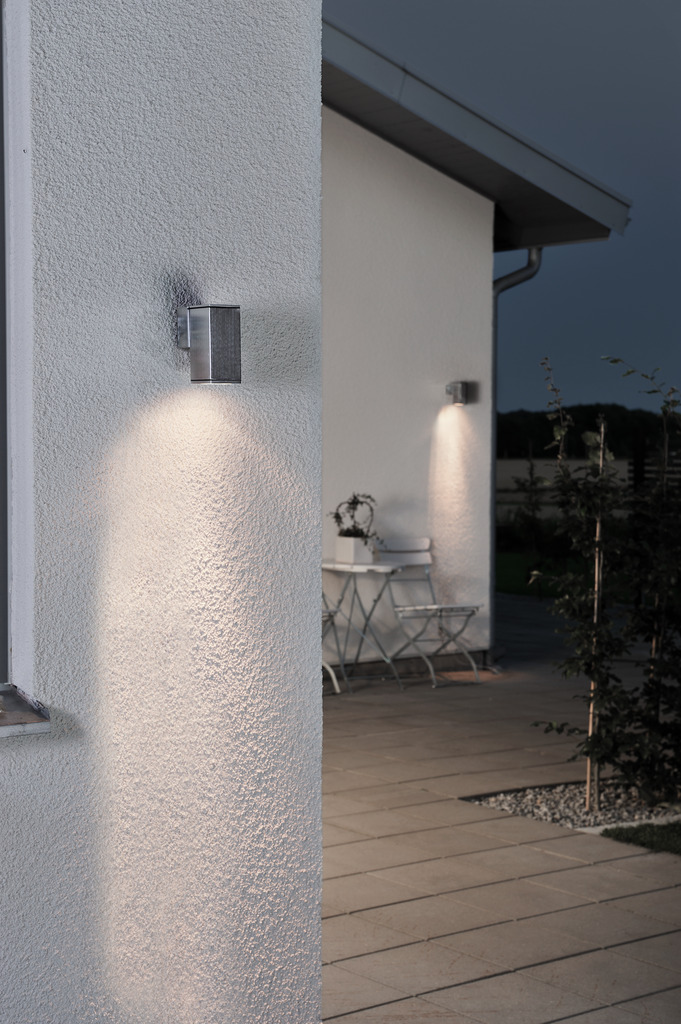 Monza Sølv udendørslampe Fra Konstsmide - Med sit terningformede design og direkte lys er den ideel til at skabe en sofistikeret atmosfære i entre og gange.