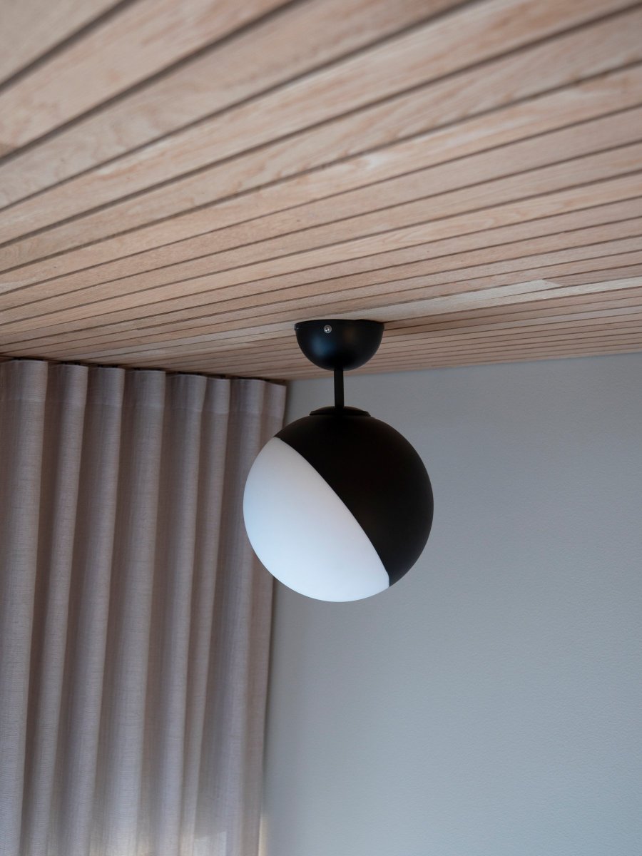 Contur Ø25 Sort badeværelseslampe Fra Globen Lighting - Lampen er lavet af mat hvidt glas hvor halvdelen af glasset er laseret i mat sort.