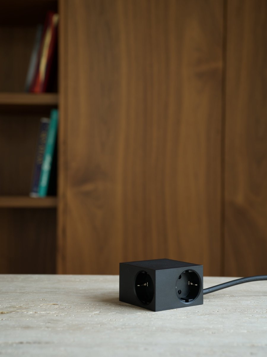 Cuboid Sort Fra Kord - Flere monteringsmuligheder - Fastg&oslash;res direkte p&aring; metalliske overflader med de magnetiske sider, brug den medf&oslash;lgende friktionsoverfladeholder til stabil placering p&aring; bordet, eller monter den p&aring; v&aelig;ggen med 3M-tape for en diskret og let tilg&aelig;ngelig stikkontakt.