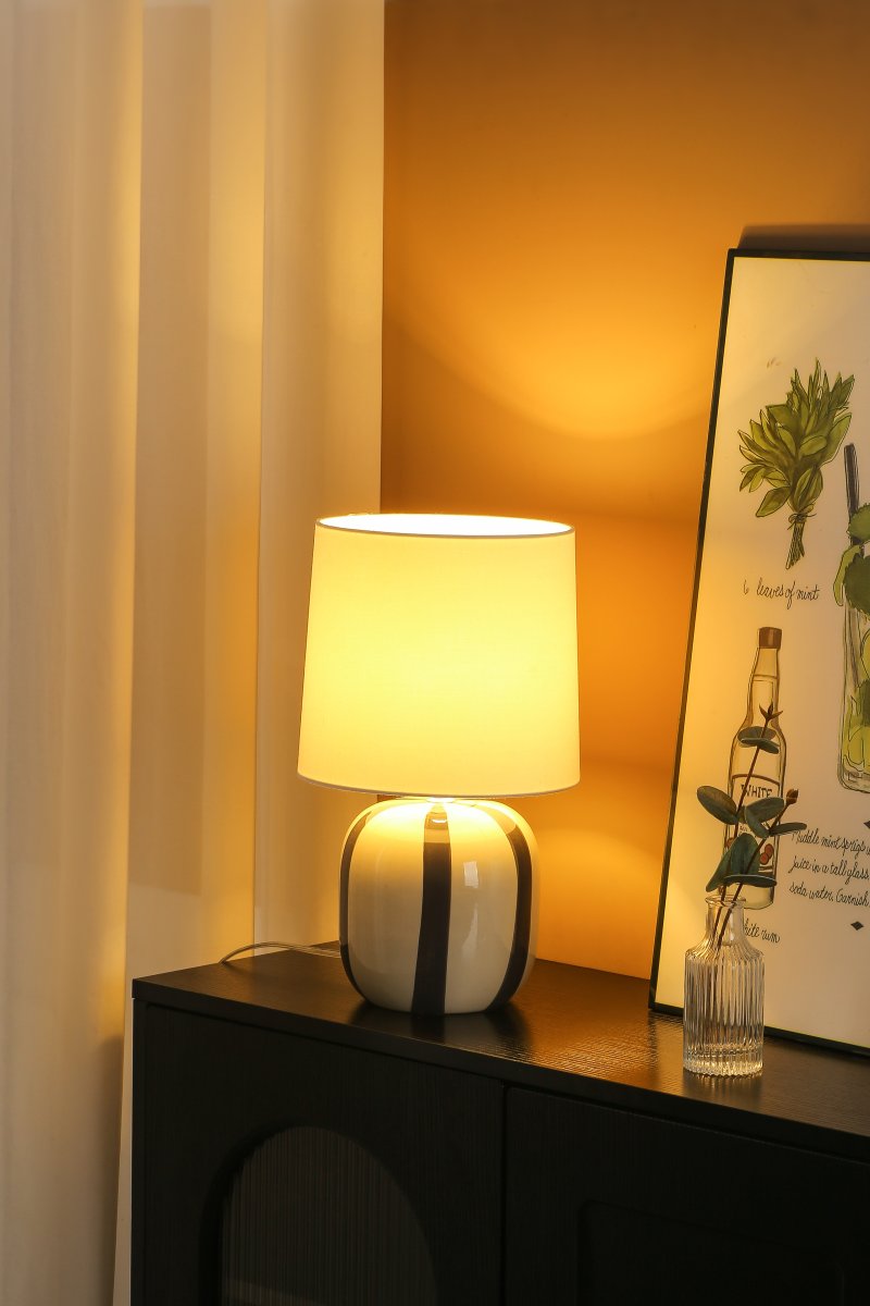 Pholca 38cm Hvid/grå bordlampe Fra Nordic Lighting - Lampefoden er lavet af keramik med en cremehvid base og gr&aring; striber, der skaber liv og karakter.