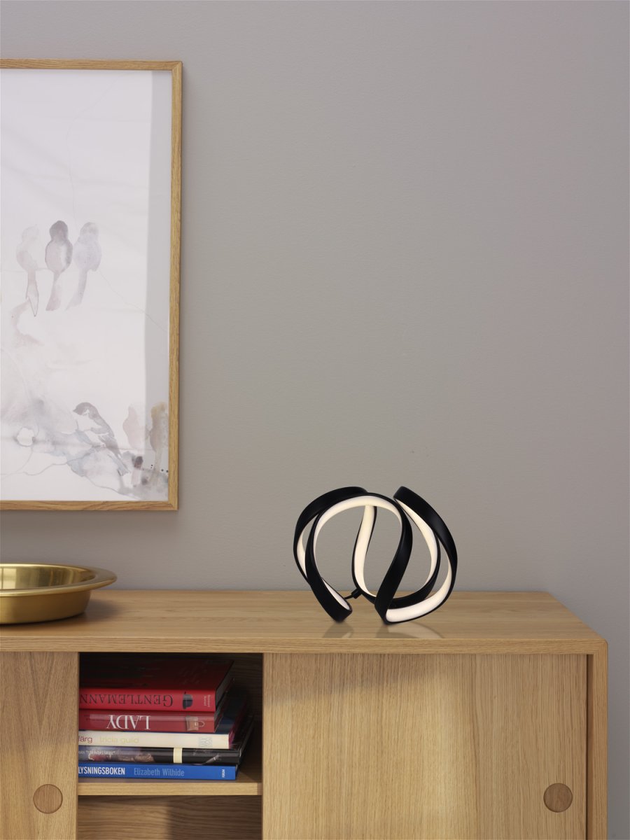 Wave 18cm Sort bordlampe Fra Cottex - Wave bordslampa i metall och silikon &auml;r en modern och elegant belysningsl&ouml;sning som ger ditt rum en unik och stilfull k&auml;nsla.